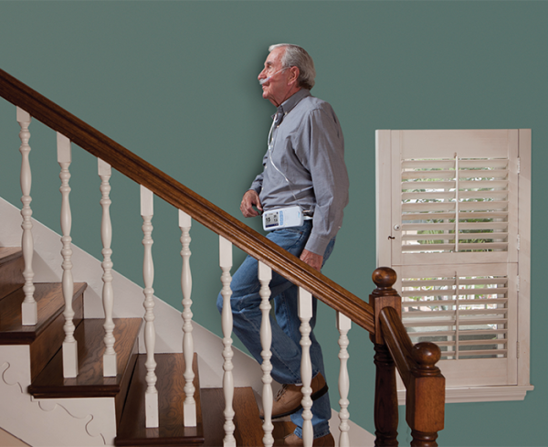 older patient walking up stairs in a home
