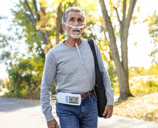 A man goes on a walk with his respiratory care device