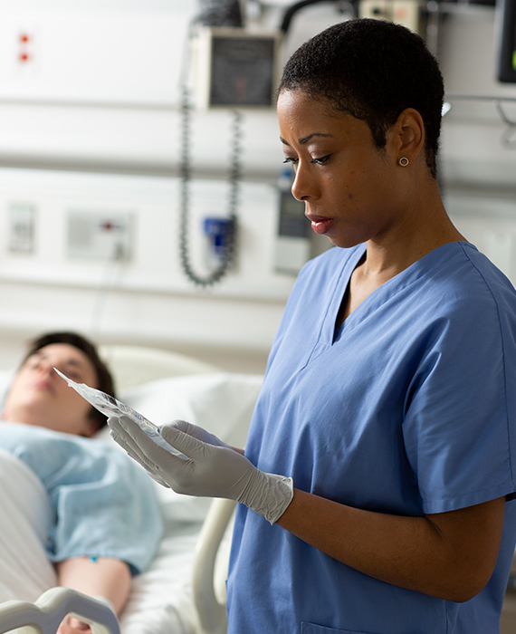 Image of nurse reviewing chart in a patient's room