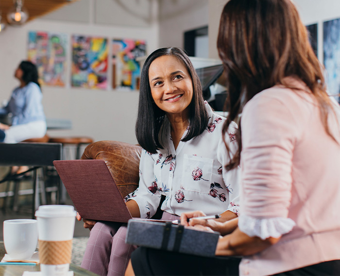 Two ladies have a discussion in a coffee shop