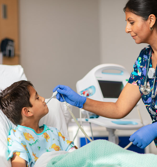 A healthcare professional takes the temperature of a pediatric patient