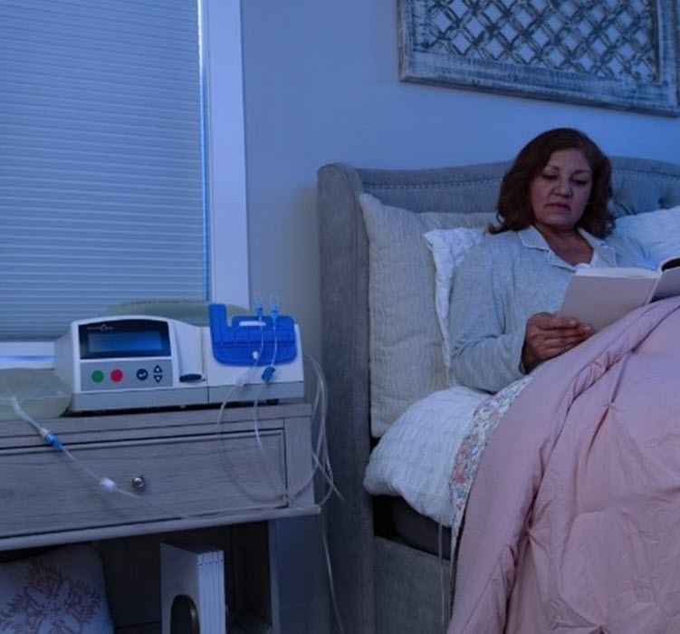 A woman does her peritoneal dialysis treatment in bed