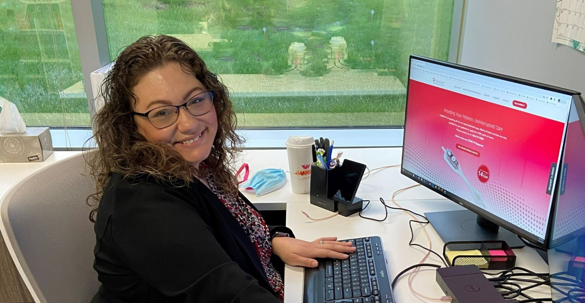 Kim sitting at her desk smiling