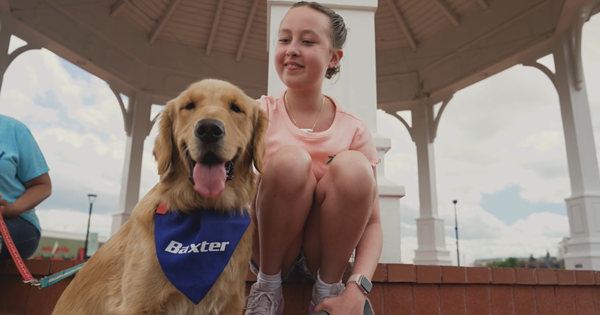 Patient pictured kneeling next to her Golden Retriever