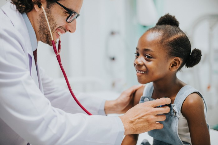 Doctor examining child with a stethoscope