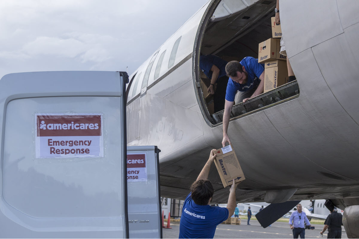 Image of volunteers unloading boxes of medical supplies from cargo plane