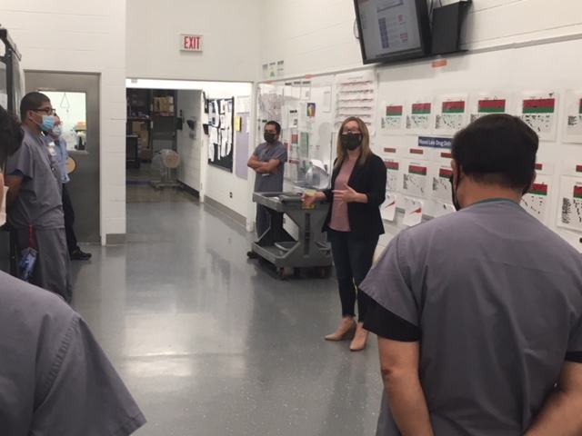 Image of a Baxter employee talking to a team inside a manufacturing facility