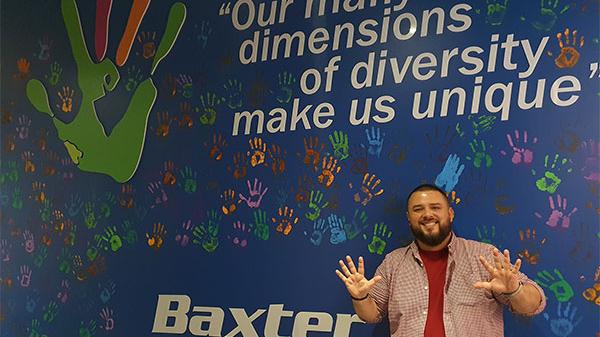Employee standing in front of inclusion and diversity wall