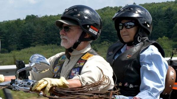 Patient riding on the back of a motorcycle with husband