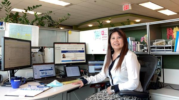 Baxter employee poses for a photo at her work station