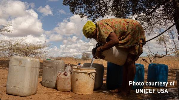 Woman pouring water into a water bucket