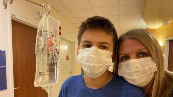 An employee and her son masked with an IV bag taken in a hospital