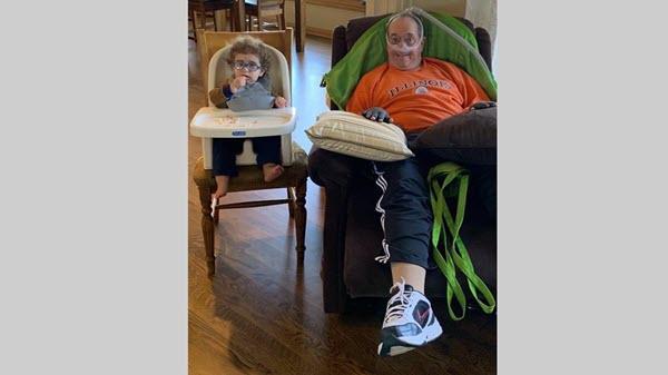 A grandfather and his grandson relax in their chairs