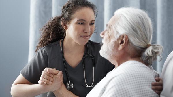 A healthcare provider assists a patient in bed