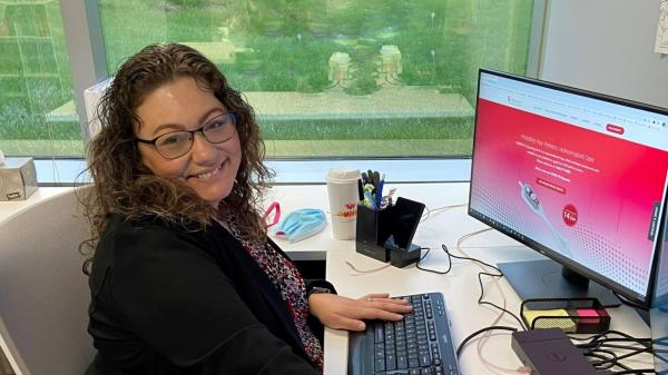 Kim sitting at her desk smiling