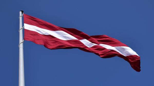 Red and White State Flag Waving Under Blue Sky at Daytime