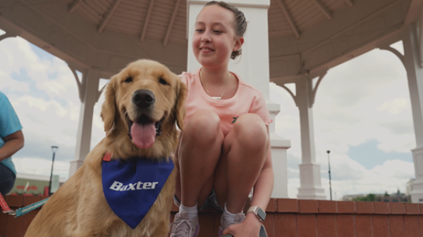 Patient pictured kneeling next to her Golden Retriever