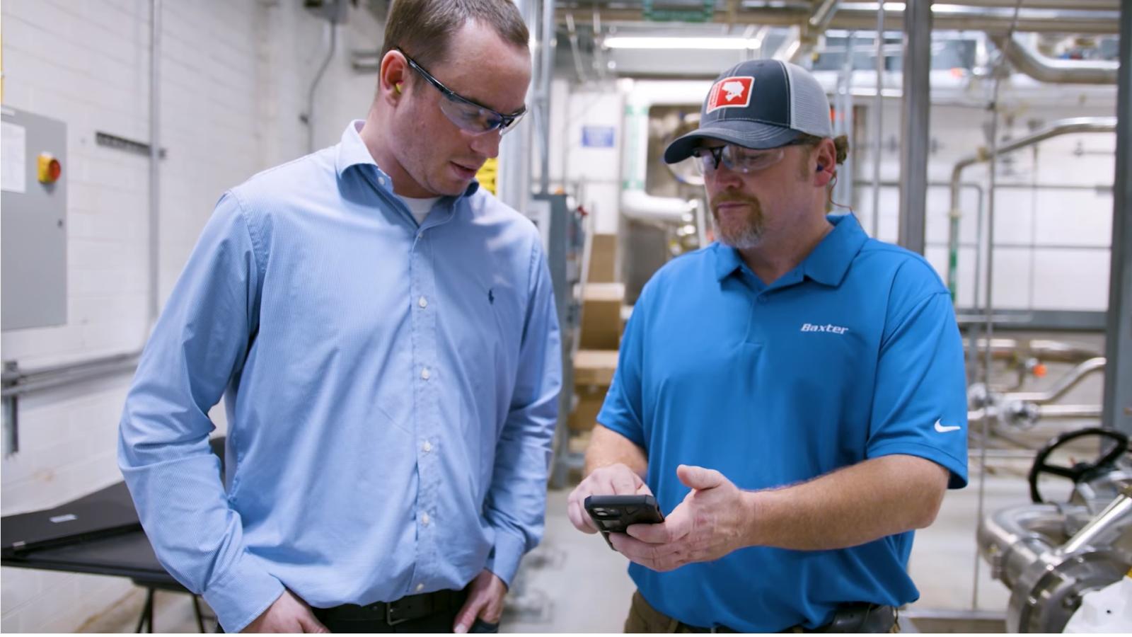 Manufacturing Employees look at a mobile device