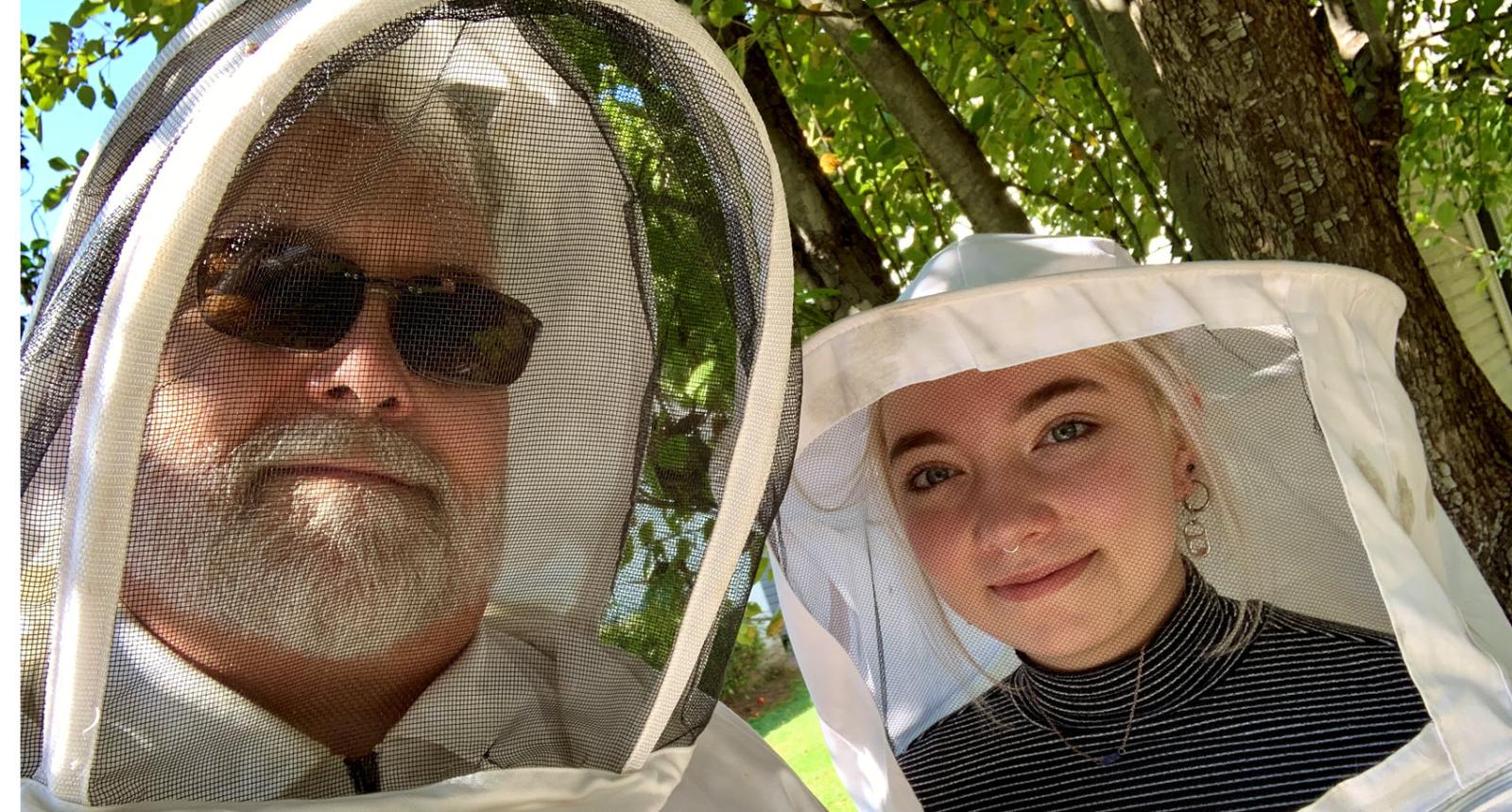 Baxter employee and his daughter wearing beekeepers' outfits