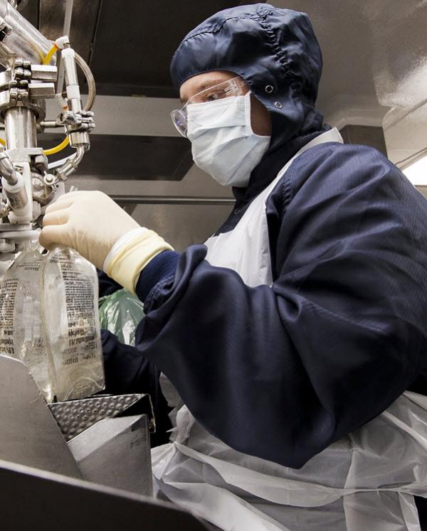 Image of a Baxter manufacturing employee in personal protective equipment working
