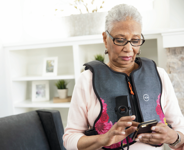 Patient wearing a medical vest interacting with mobile device
