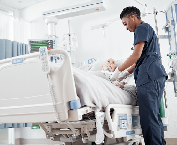 Healthcare professional assisting a patient in a hospital bed