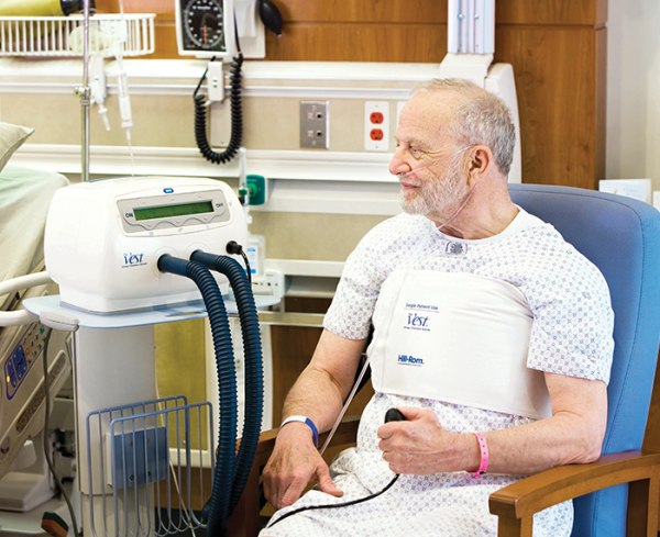 Patient wearing a medical vest interacting with medical device in a hospital setting