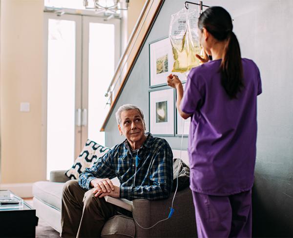 Patient in his living room receiving nutrition via IV