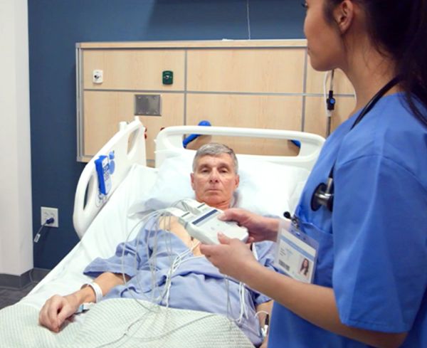 Healthcare professional assisting a patient in a hospital bed