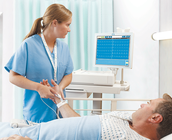 Healthcare professional assisting a patient in a hospital bed