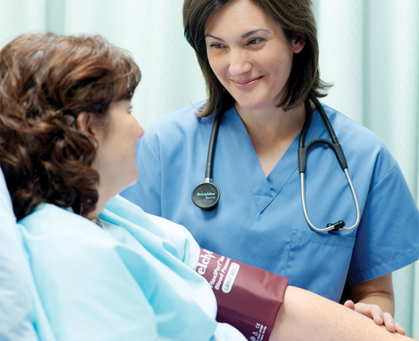 Healthcare professional using a blood pressure cuff on a patient