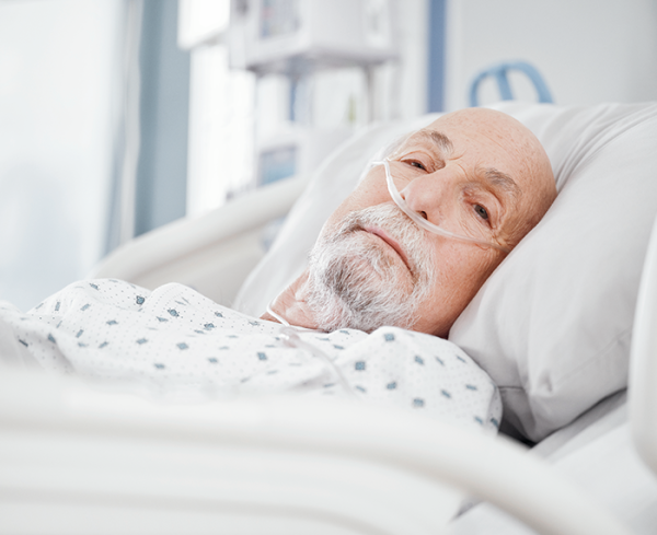 Patient in a hospital bed using a nasal breathing tube