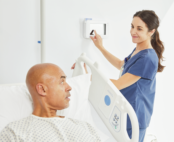 Healthcare professional assisting a patient in a hospital bed