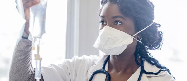 Healthcare professional looks at an IV bag