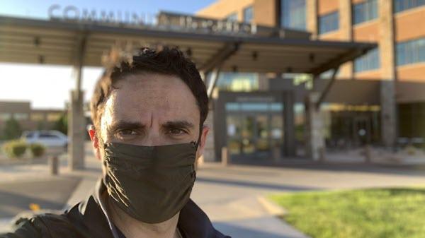 Baxter employee masked and standing outside of a hospital