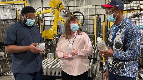 A Baxter plant manager talks to employees in a manufacturing setting