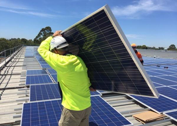 Image of a man carrying a solar panel